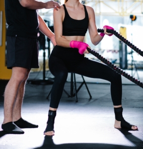Foto di esempio che ritrae una ragazza che si allena con un personal trainer nella sua palestra personale