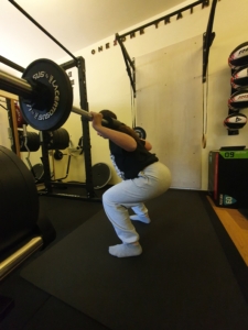 Membro Esclusivo di One2One Training Club mentre performa uno squat con bilanciere - membri in azione!